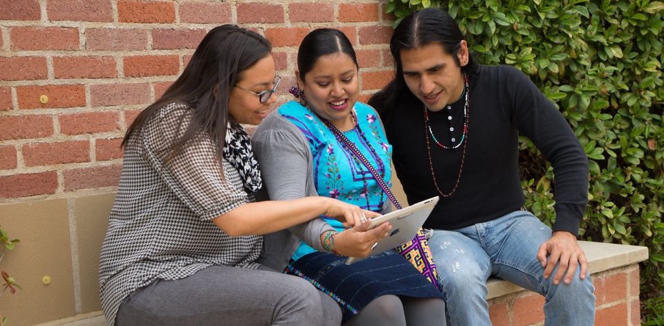 photo of three native americans viewing a shared ipad
